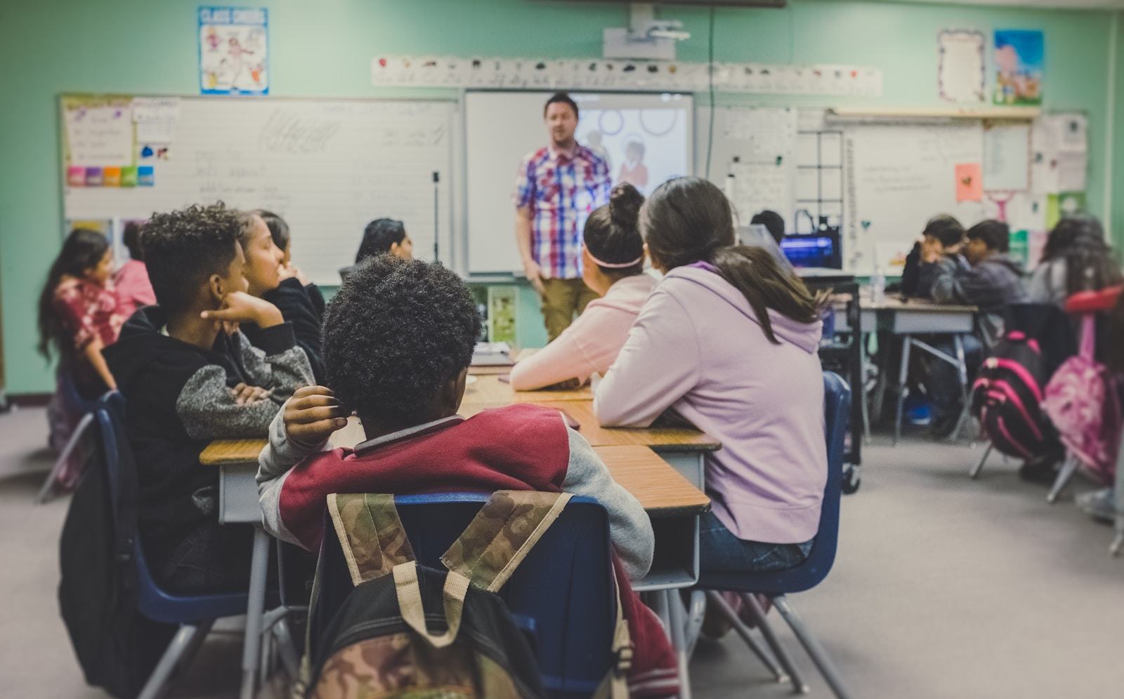 Professor diante de uma turma de estudantes em sala de aula.